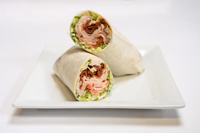Turkey BLT Wrap cut in half, filled with sliced turkey, bacon, lettuce and tomato